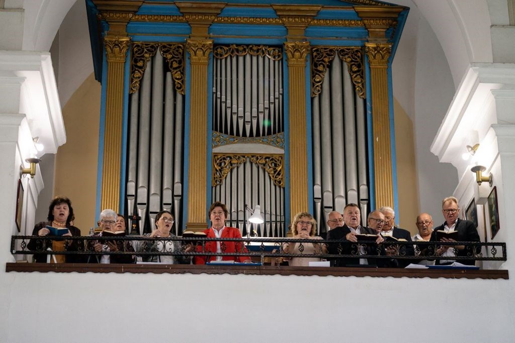 Župni zbor pjeva pred orguljama iz 1855. godine s pozlaćenim plavo-zlatnim ukrasom u koru župne crkve.